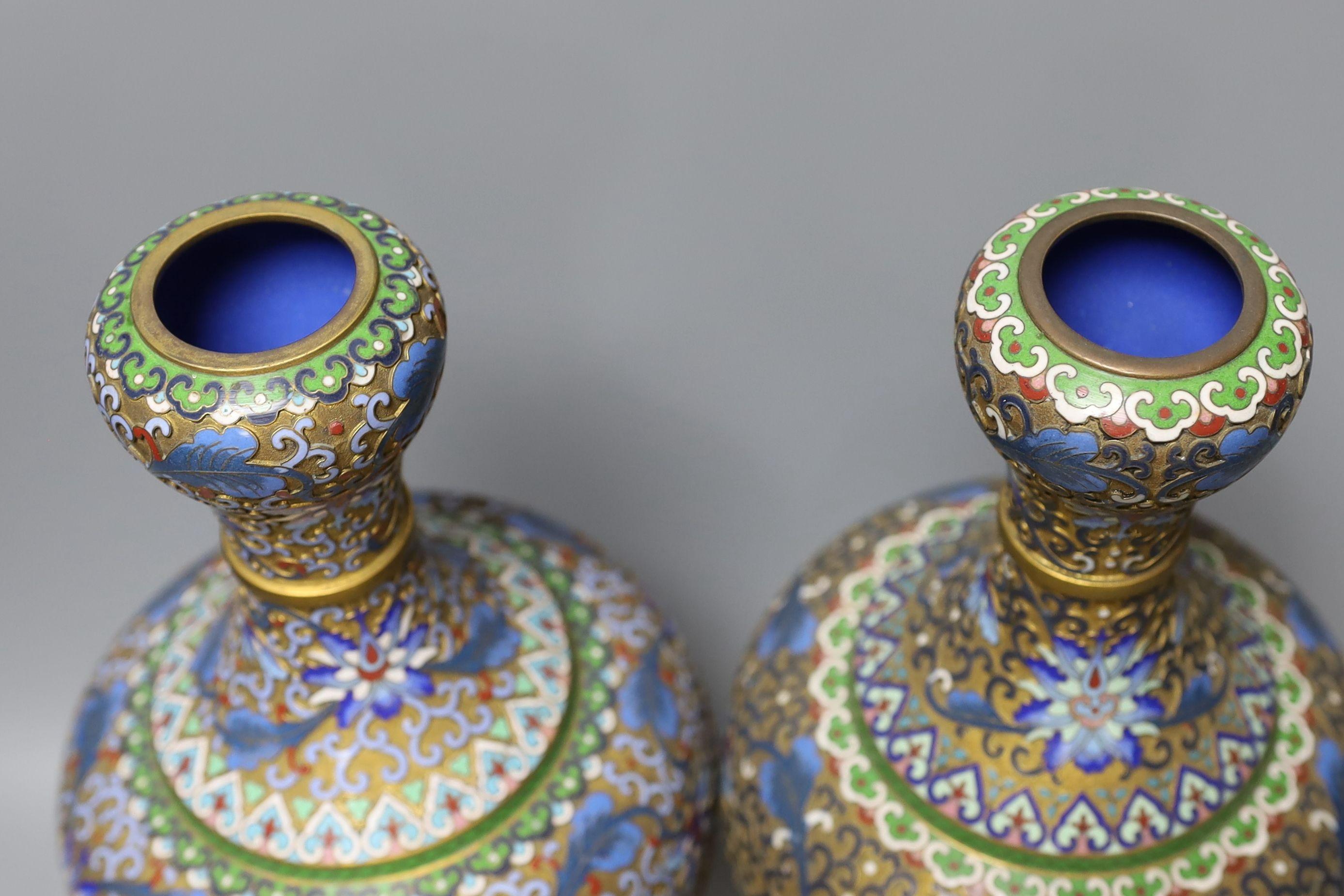 A pair of Chinese cloisonné enamel vases, on carved wood plinths, 30cm